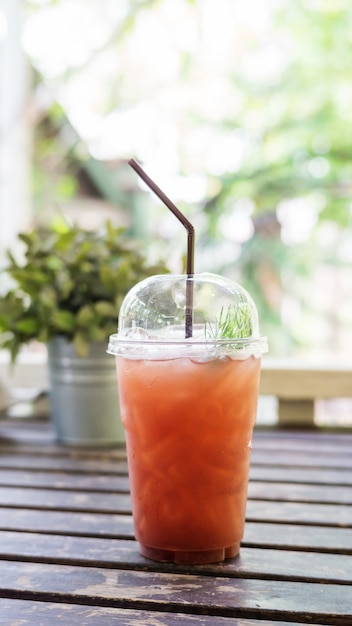 Thé glacé aux fruits sur une table en bois dans un café.