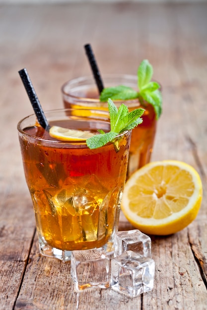 Thé glacé traditionnel au citron, feuilles de menthe et glaçons dans deux verres