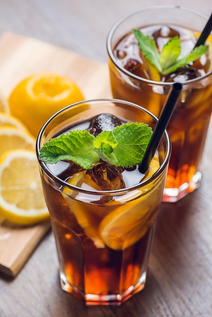 Thé glacé traditionnel réfrigéré à la menthe citronnée et glace sur table rustique