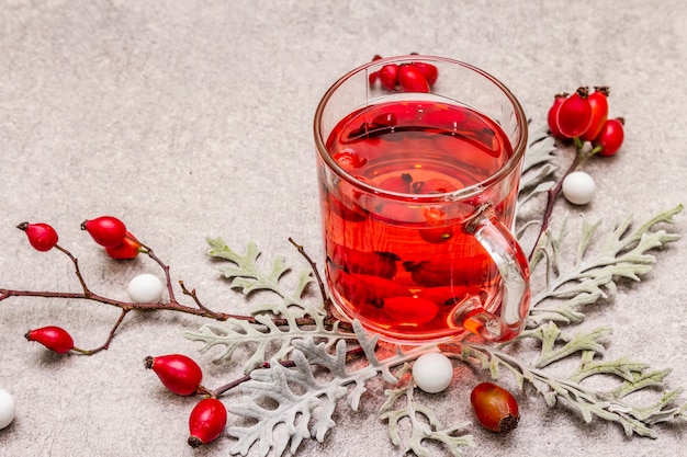 Thé à la hot dog-rose. Boisson d'hiver pour la bonne humeur avec des baies fraîches, des feuilles et des bonbons.