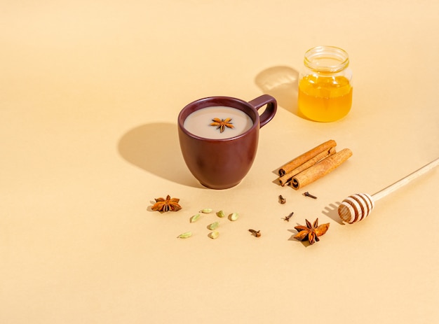 Thé indien traditionnel. Thé Masala dans une tasse d'argile foncée avec des ingrédients