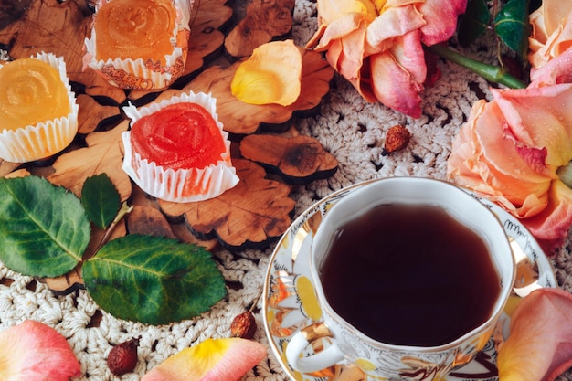 Le thé avec la marmelade sur la table sont des fleurs roses.