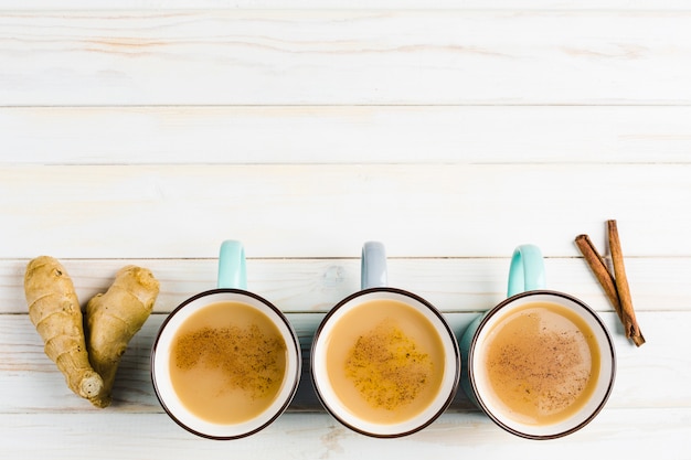 Thé Masala dans des tasses en céramique avec des épices d'hiver à la cannelle et au gingembre