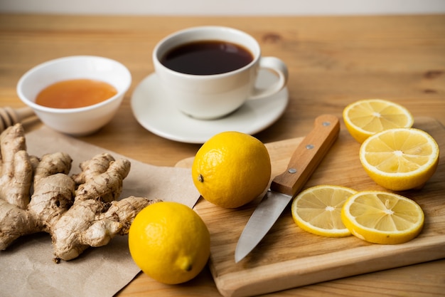 Thé, miel, citron et gingembre sur une table en bois