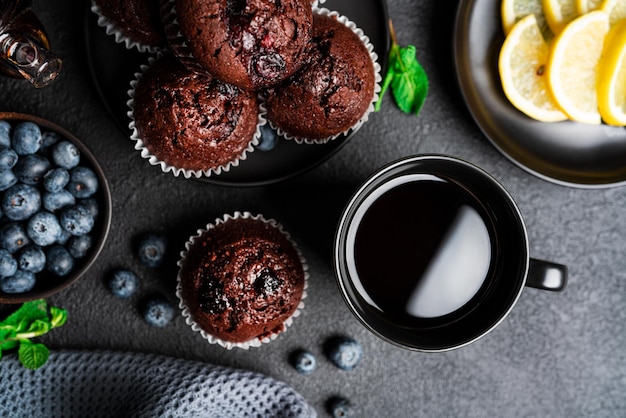 Thé avec muffins sur fond sombre Muffins au chocolat aux myrtilles