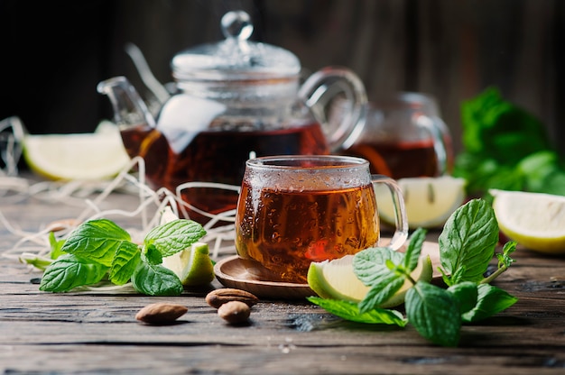 Photo thé noir chaud au citron et à la menthe sur la table en bois