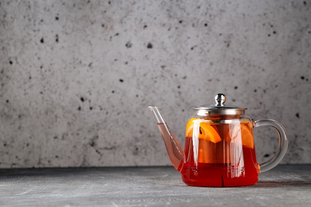 Photo thé noir chaud et sain au citron dans une théière en verre