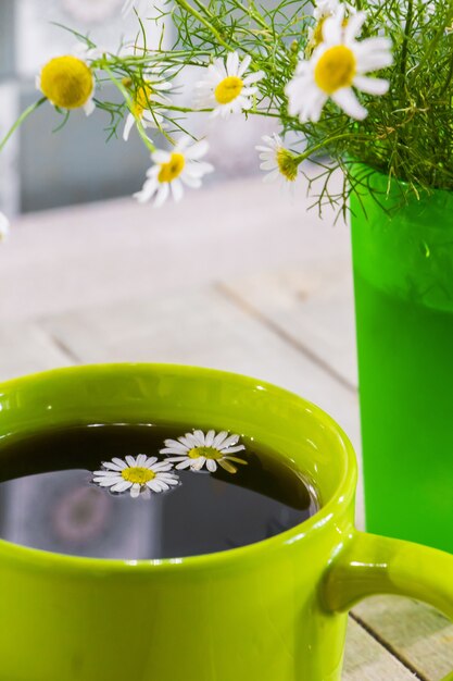 Thé noir dans une tasse verte à la camomille.