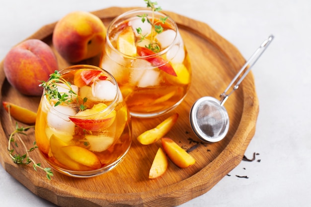 thé noir glacé maison aux pêches et thym dans des verres