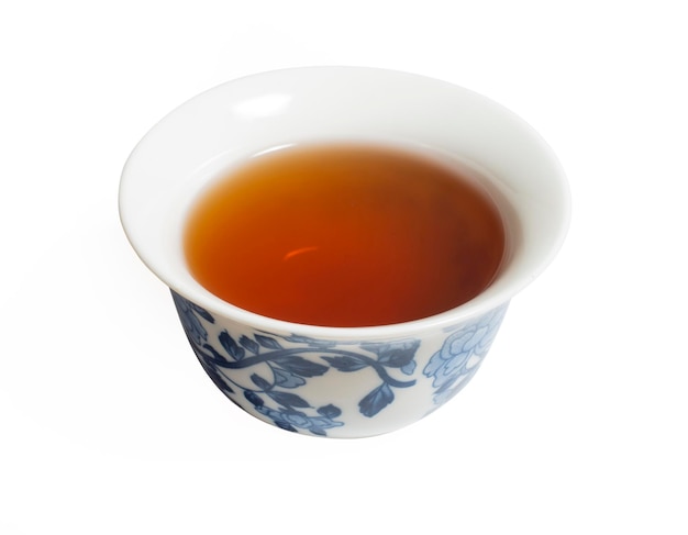 Thé oolong chinois sec dans une tasse traditionnelle sur blanc