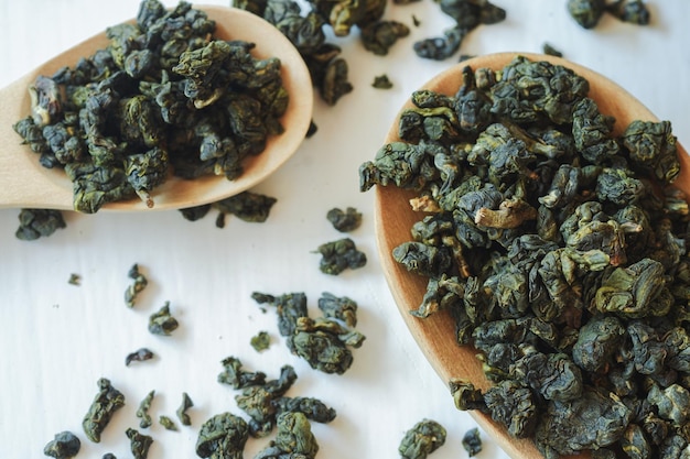 Thé Oolong ou thé chinois dans une cuillère en bois C'est un thé sain qui peut aider à réduire les lipides sanguins