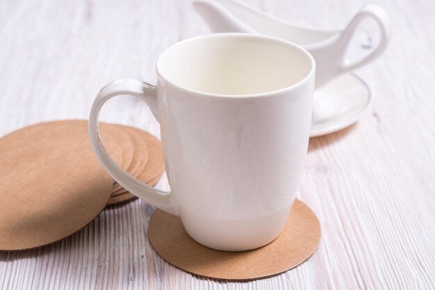 Thé potvelain blanc de tasse de café sur des sous-verres en carton rond, coussin de tasse, tapis, support