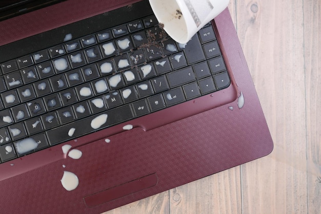 Thé renversant sur un clavier d'ordinateur portable sur la table