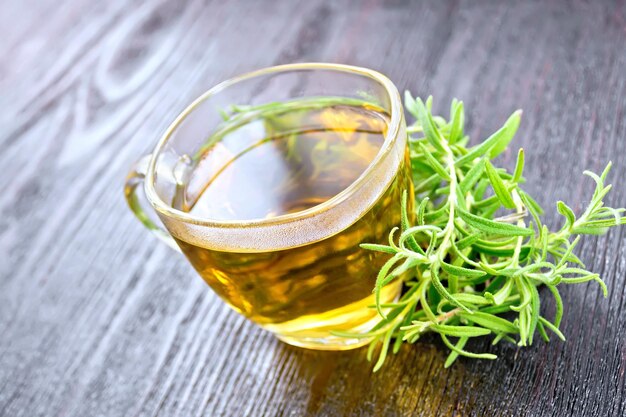 Thé de romarin en tasse sur planche de bois