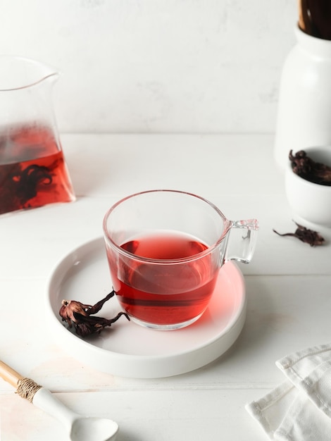 Thé rosella chaud dans une tasse transparente sur fond blanc Mise au point sélectionnée