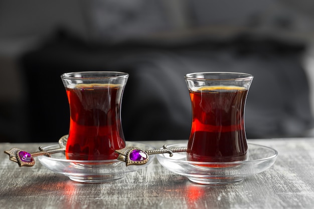 Thé rouge dans des verres turcs sur une table en bois
