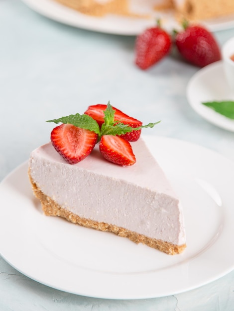 Thé sucré pour le petit-déjeuner et délicieux gâteau au fromage avec des fraises fraîches et une recette maison à la menthe sans cuisson sur une table en pierre bleue Copier l'espace