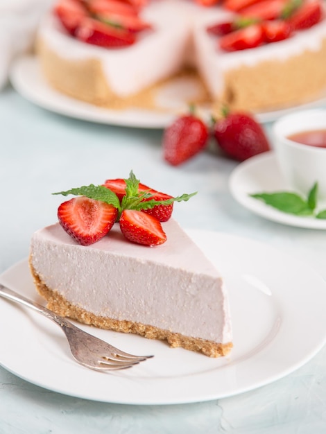 Thé sucré pour le petit-déjeuner et délicieux gâteau au fromage avec des fraises fraîches et une recette maison à la menthe sans cuisson sur une table en pierre bleue Copier l'espace