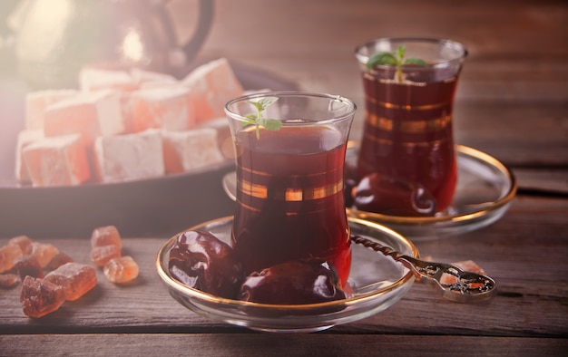 Thé turc dans des tasses en verre traditionnelles sur la table en bois