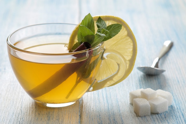 Thé vert au citron et cannelle dans une tasse en verre