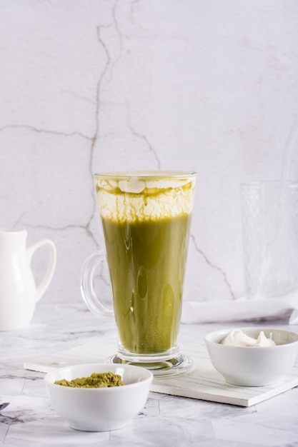 Thé vert au fromage matcha dans un verre sur la table Boisson tendance faite maison Vue verticale