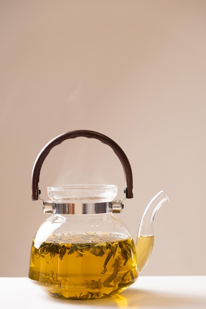 Thé vert de Chine aux zestes d'orange dans une théière en verre