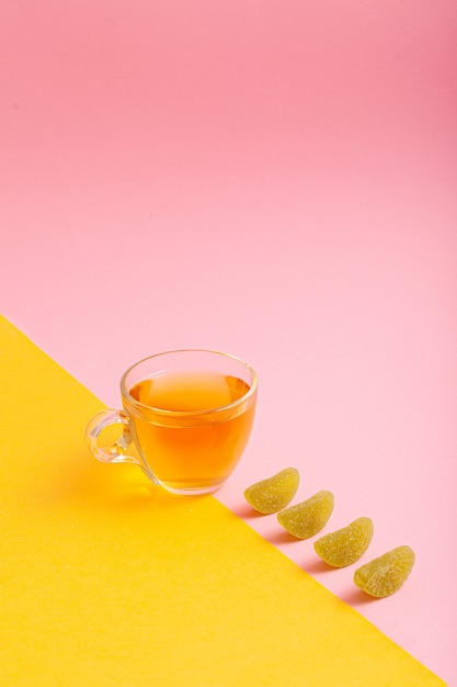 Thé vert dans une tasse sur fond rose