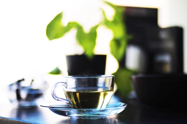 Thé vert fumant chaud dans une tasse sur un fond rustique