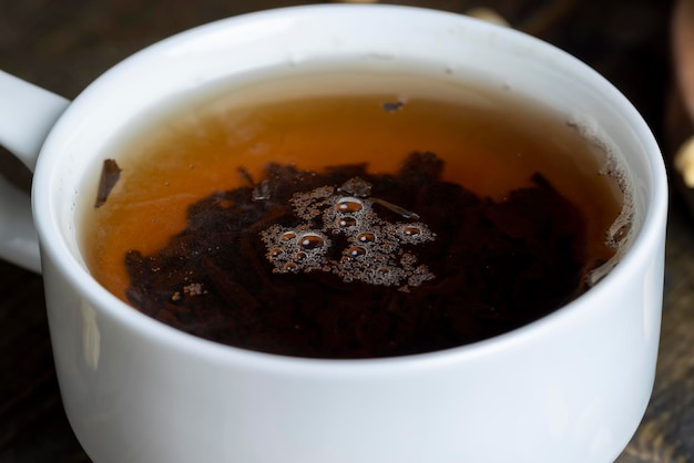 Thé vert infusé dans une tasse en porcelaine blanche