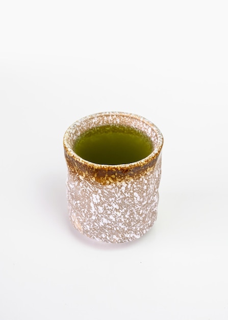 Thé vert matcha chaud biologique dans une tasse en céramique