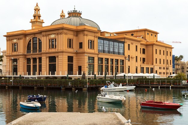 Photo théâtre margherita et bateaux de pêche dans le vieux port de bari pouilles italie