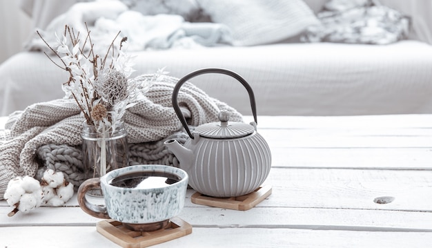 Une théière et une belle tasse en céramique avec des détails de décoration dans un salon de style hygge. concept de confort de la maison et de style moderne.