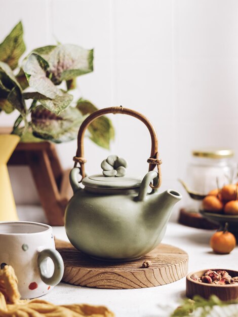 Photo une théière en céramique verte sur la table. photographie de nature morte d'humeur lumineuse.