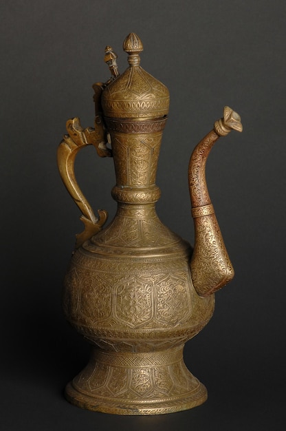 Théière en métal oriental antique sur fond sombre vaisselle en bronze antique