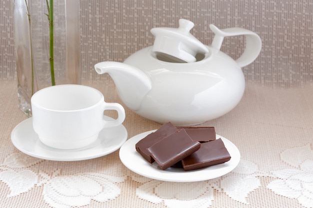 Théière, tasse et chocolat sur une assiette