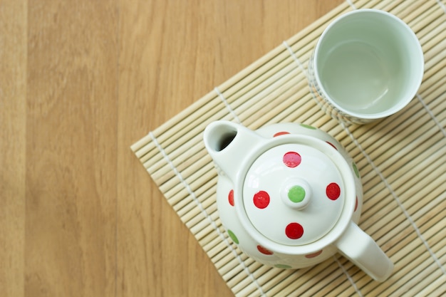 Théière et tasse sur la table en bois.