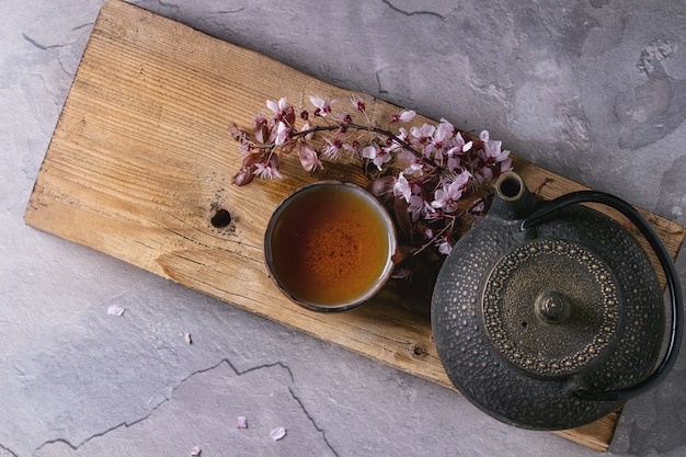 Théière et tasse de thé avec branche de fleur
