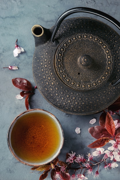 Théière et tasse de thé avec une branche de fleur