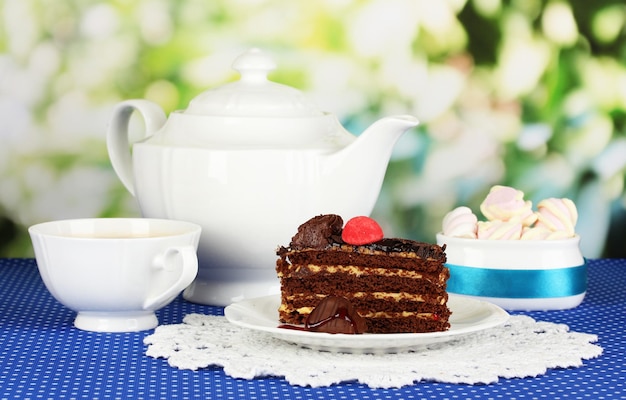 Théière tasse de thé et délicieux gâteau sur fond naturel