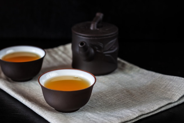 Théière et tasses brunes chinoises sur une table en bois noire