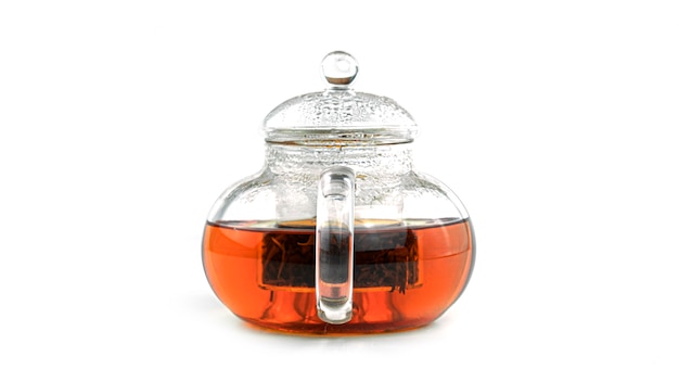 Théière transparente avec du thé isolé.