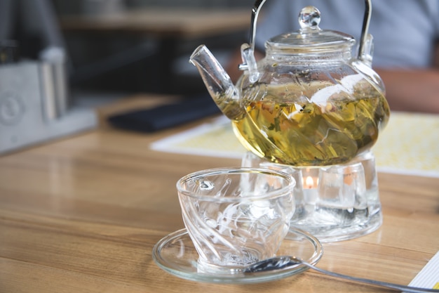 Théière en verre et tasse en verre avec tisane