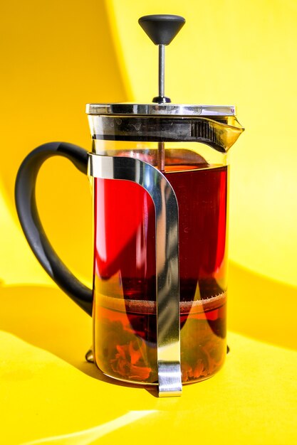 théière en verre avec thé d'hibiscus chaud Thé aux fruits frais et épicé aux herbes, fleurs de rose, chaud