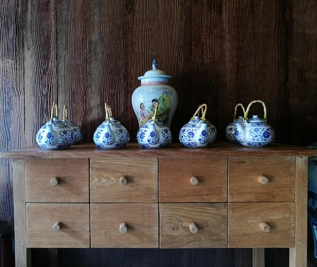 Des théières sur la table contre le mur.