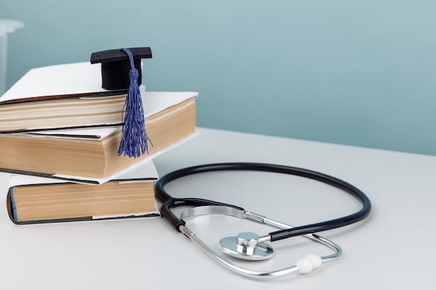 Thème de l'éducation médicale et de la santé. Stéthoscope et chapeau de graduation sur pile de livres.