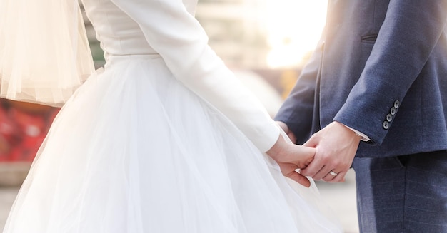 Photo thème de mariage couple main dans la main sur les images de mariage des amoureux de fond coucher de soleil en célébration