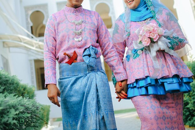 Photo thème de mariage tenant par la main les jeunes mariés