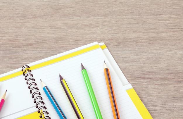 Thème Office Des crayons simples avec une coque multicolore se trouvent sur un cahier ouvert
