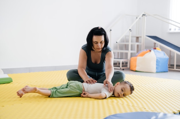 Thérapeute faisant la réadaptation des enfants avec la paralysie cérébrale