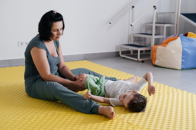 Thérapeute faisant la réadaptation des enfants avec la paralysie cérébrale